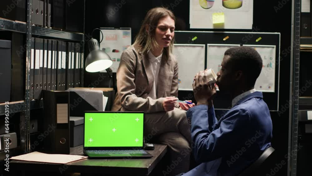 Policewoman talks with black man drinking coffee in office, with laptop ...