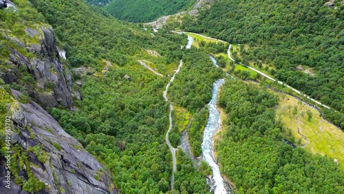 4K drone flying all the way down Briksdalen Valley. Tourist buses, rivers and waterfalls. Glacier water and beautiful nature.  photo