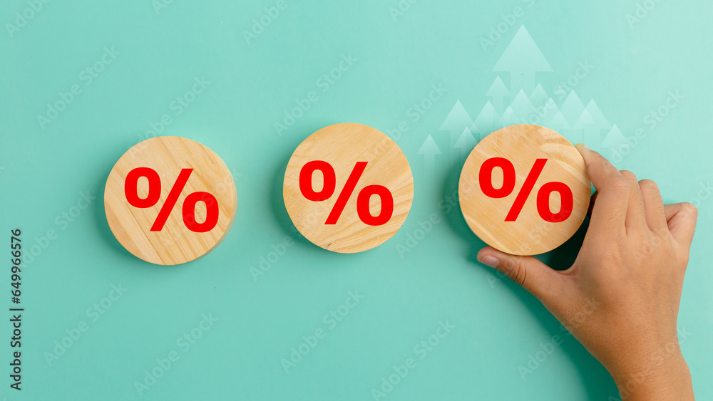 Interest rate finance and mortgage rates concept. Hand holding wooden circle with percentage sign arrow rise, financial growth, interest rate increase, inflation, sale price and tax rise concept. - obrazy, fototapety, plakaty 