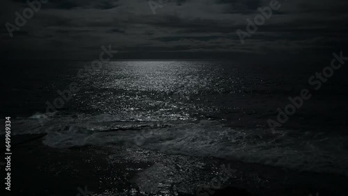 Big ocean waves crashing onto the rocky shore during at night