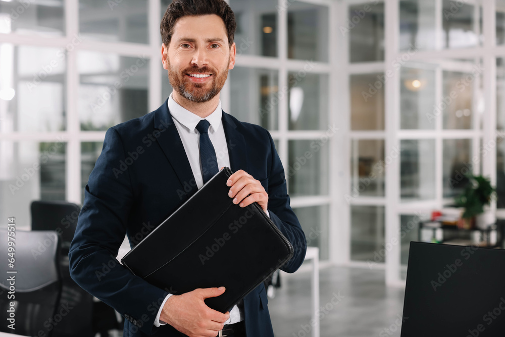 Fototapeta premium Happy real estate agent with leather portfolio indoors. Space for text