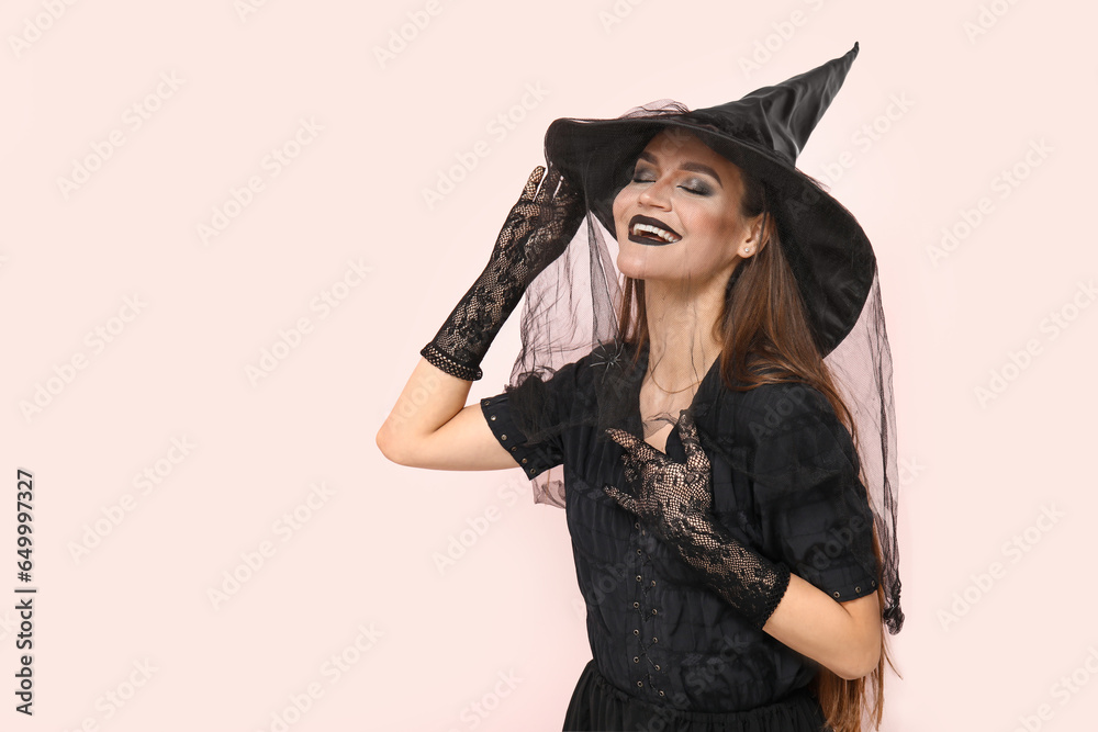 Young woman dressed for Halloween as witch on light background Young woman dressed for Halloween as witch on light background