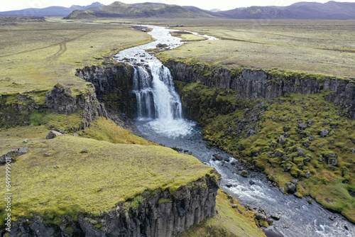 Aerial view of waterfall and volcanic plains in Fjallabak Nature Reserve, Iceland on sunny autumn day.