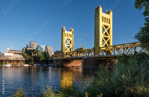 Fototapeta Naklejka Na Ścianę i Meble -  Photo of the golden Tower Bridge over the Sacramento River. The bridge is the western downtown entry point to the city of Sacramento, capital of California.