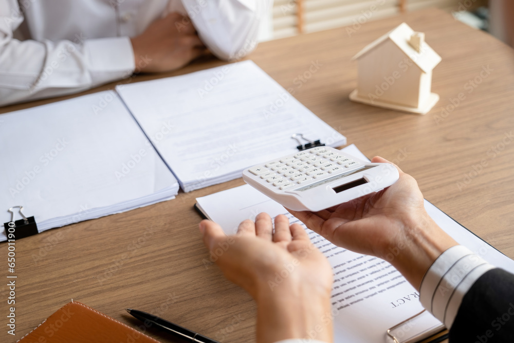 Real estate agent calculating house price for buyer. Real estate agent calculating house price for buyer.