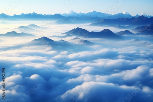 A breathtaking aerial view of majestic mountains peeking through fluffy white clouds