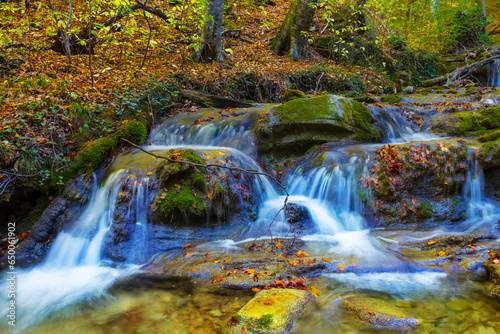 small waterfall on river flow through the mountain canyon, autumn mountain river scene