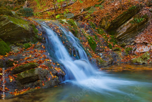 small waterfall on river flow through the mountain canyon, autumn mountain river scene © Yuriy Kulik