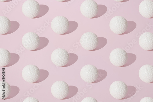 Arranged white golf ball on pink pastel background. Pattern. photo