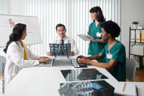 Doctors and medical nurses having meeting, discussing xrays images