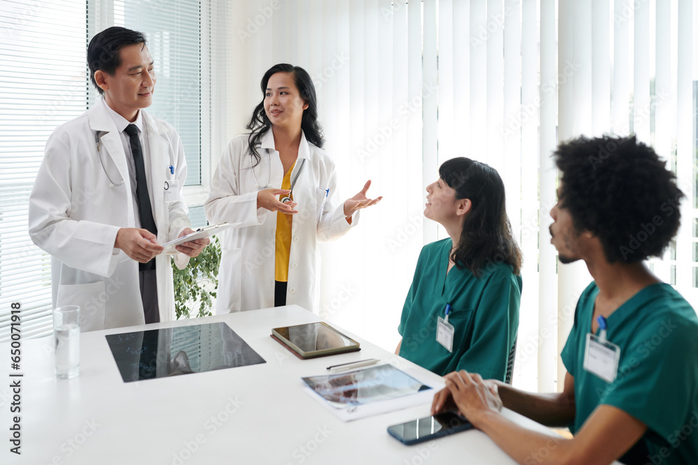 Doctor talking to new nurses, integrating them into organization Doctor talking to new nurses, integrating them into organization