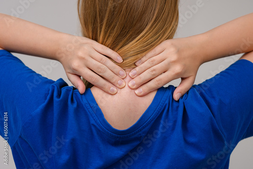 Kobieta trzymająca dłonie na swoim karku, ból szyi z tyłu 