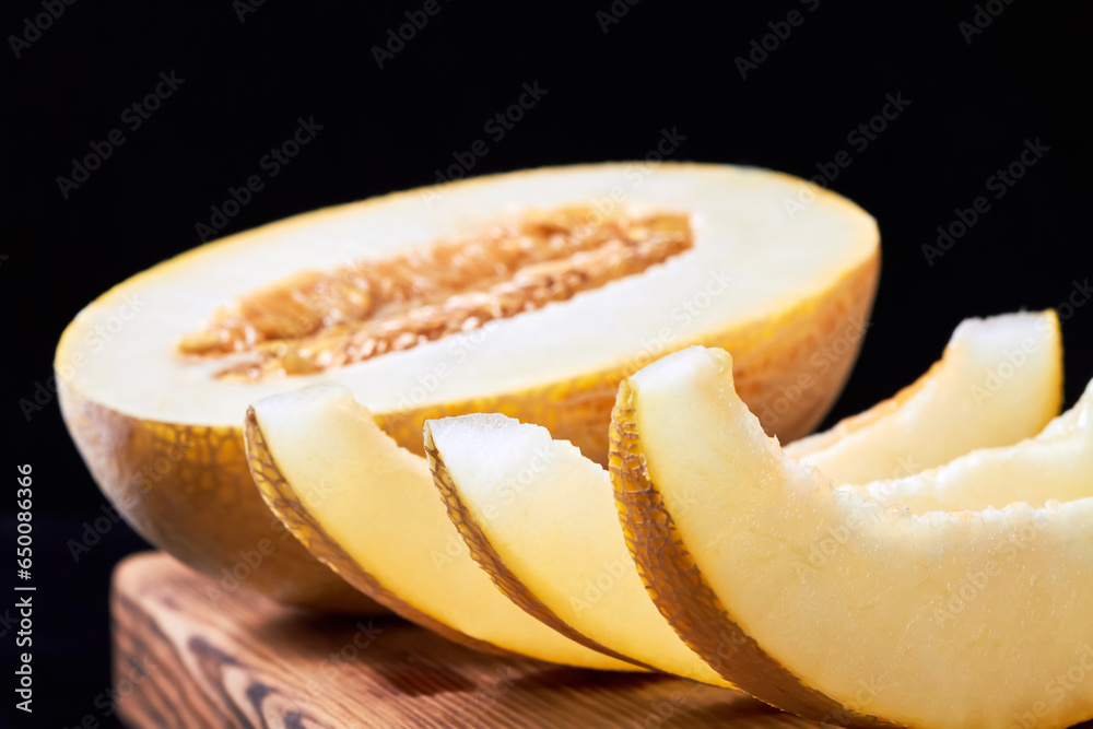 Close-up of melon slices and melon halves on a wooden board