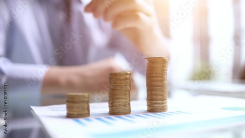 Businessman stacking coins on table, business growth concept. Hand puts coin to stack.