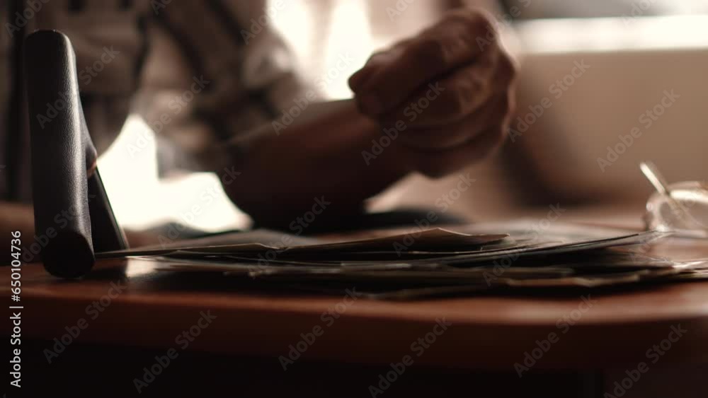 hands of a pensioner holding and looking at family black and white photos while at home. concept nostalgia, family photos, emotions of old people hands of a pensioner holding and looking at family black and white photos while at home. concept nostalgia, family photos, emotions of old people