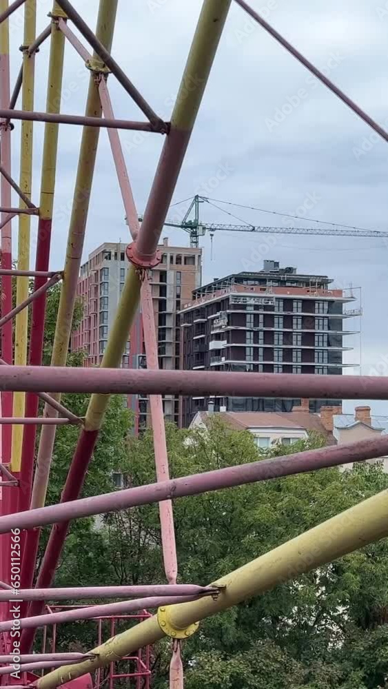 filming a video from a Ferris wheel in the city of Vinnitsa, Ukraine old attractions view of the city Tall iron wheel in the park colorful baskets green trees. rainy sky filming a video from a Ferris wheel in the city of Vinnitsa, Ukraine old attractions view of the city Tall iron wheel in the park colorful baskets green trees. rainy sky
