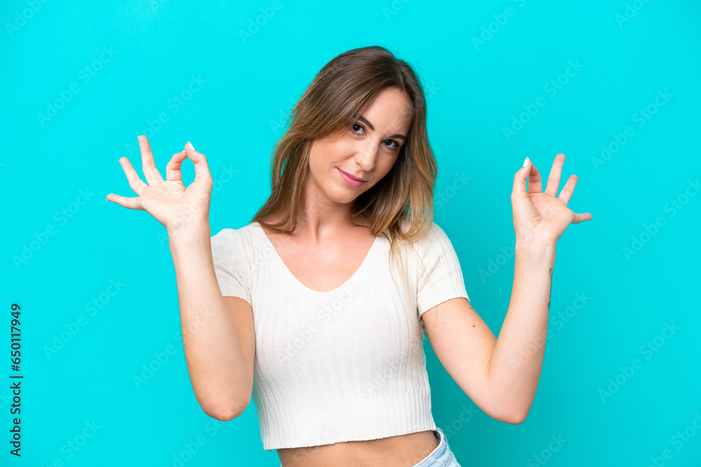Young caucasian woman isolated on blue background in zen pose Young caucasian woman isolated on blue background in zen pose