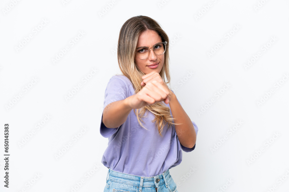 Young Uruguayan woman isolated on white background with fighting gesture Young Uruguayan woman isolated on white background with fighting gesture