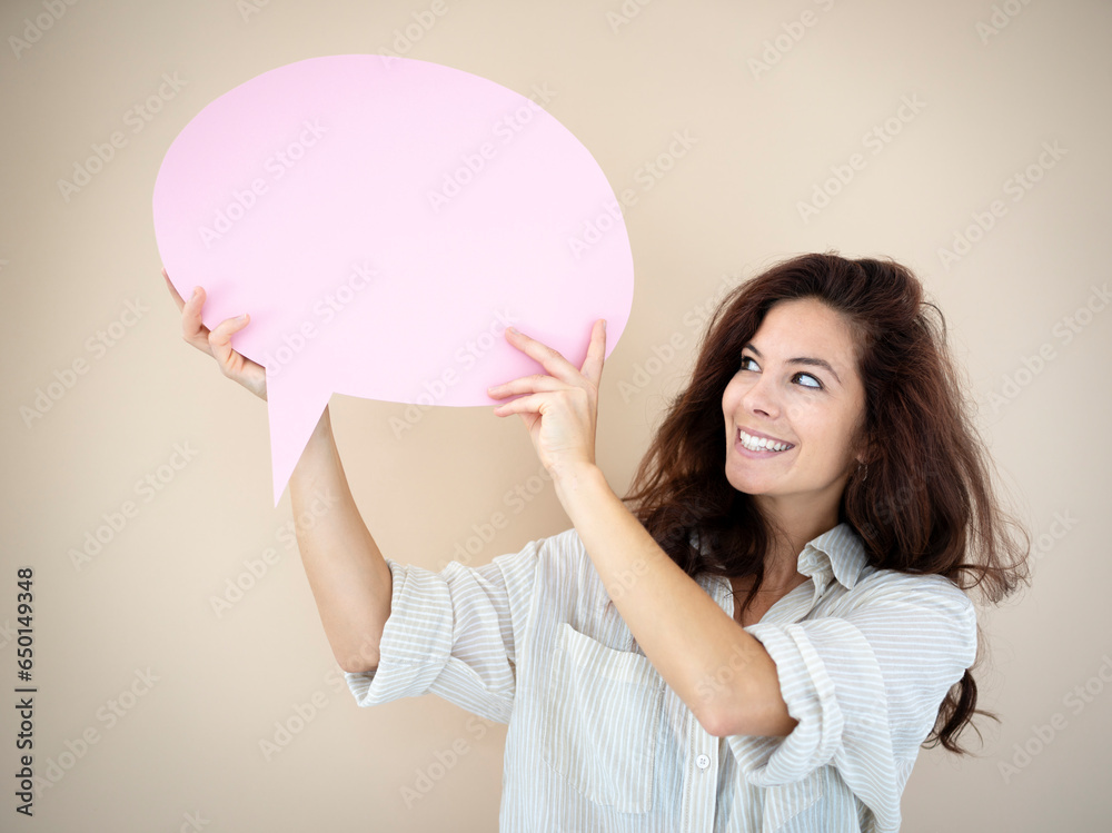 beautiful young woman with pink speech bubble in front of brown background beautiful young woman with pink speech bubble in front of brown background