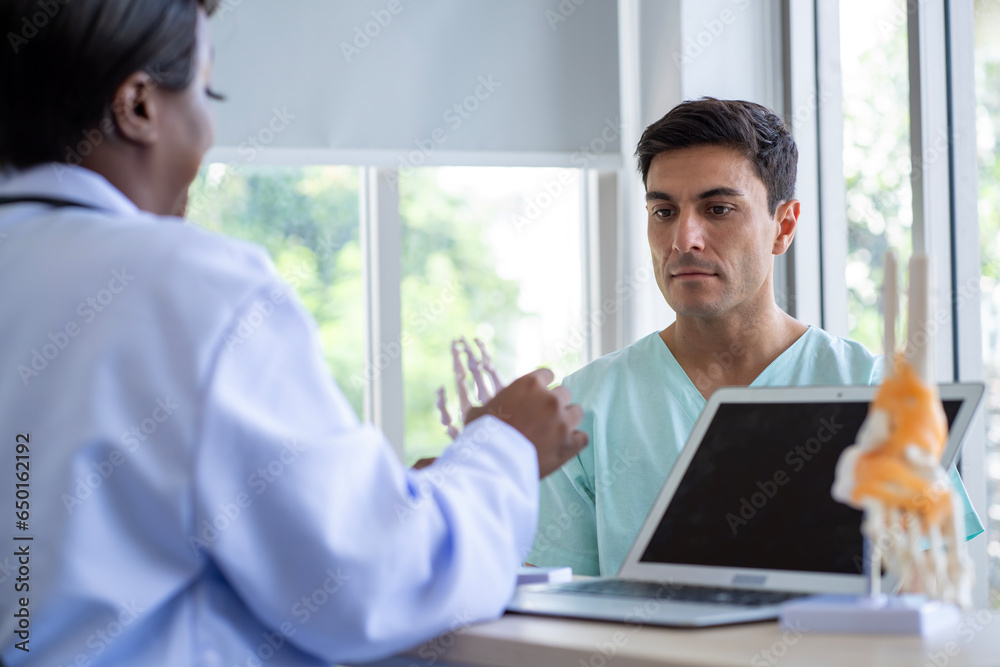 Female doctor and male patient Discuss and give advice about wrist and arm pain among patients in the hospital. Female doctor and male patient Discuss and give advice about wrist and arm pain among patients in the hospital.