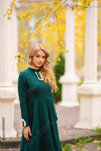 Beautiful blonde curly young girl in green long vintage dress and lace  standing near alcove in autumn park.Pretty tenderness model looking at camera.Art work and fairytale © Ольга Бойко