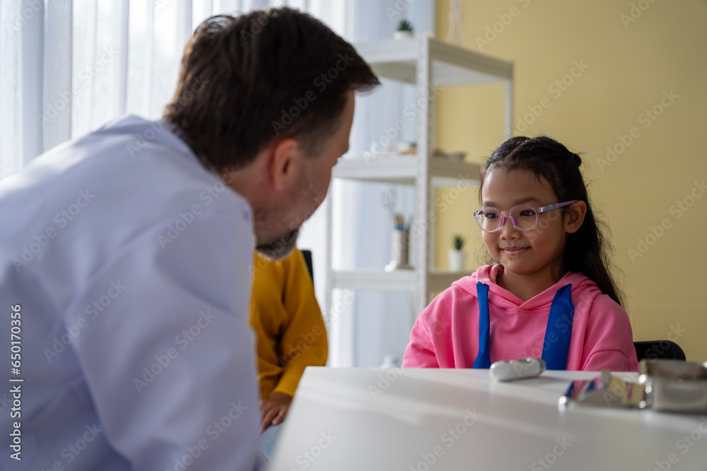 Obraz premium Male doctor and girl young patient Talk and give advice about your illness at the hospital.
