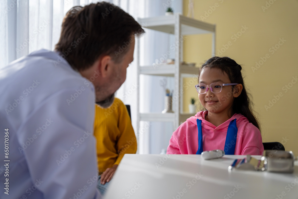 Obraz premium Male doctor and girl young patient Talk and give advice about your illness at the hospital.