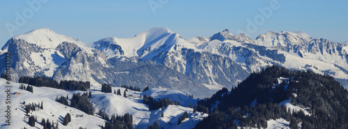 Snow covered mountains Schafberg and Kaiseregg. Winter landscape near Zweisimmen, Swiss Alps.. photo