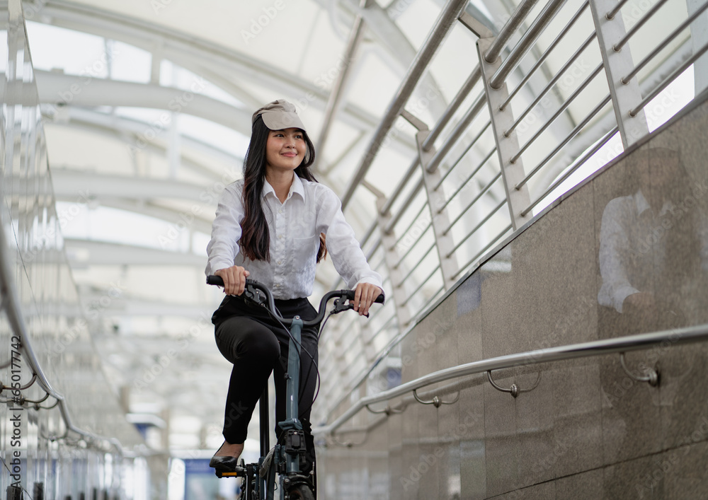 Eco friendly vehicle. 20s businesswoman ride bicycle to work in urban. Cycling is pollution free, alternative commute to global warming. Help environmental preservation by bicycling. Commuting by bike