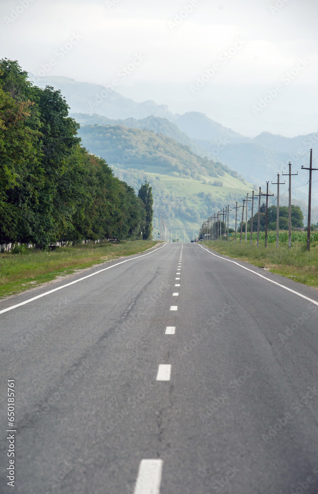 Beautiful empty asphalt road against the backdrop of mountains in summer
