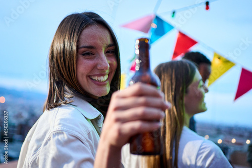 Wall Mural Portrait pretty young Caucasian woman toasting bottle beer in hand smiling