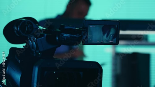 Close up detail video of the camera filming, recording the face of a suspect, offender, perpetrator or prisoner talking to a detective, policeman standing on the background. photo