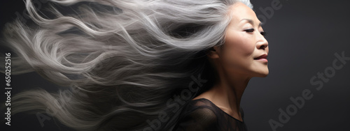 Portrait of senior mature middle aged lady with long gray natural coloring vibrant silky hair.