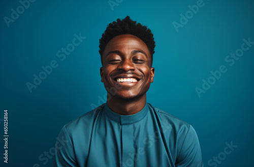 Portrait of African American priest smiling eyes closed. Against backdrop. Religion concept.