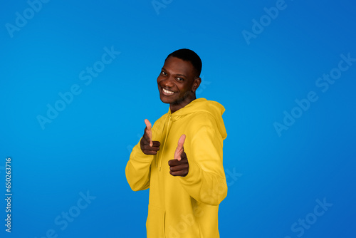 Positive confident young black guy point fingers at camera