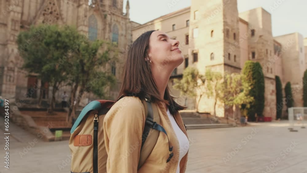 Woman looking around when standing on the square of an old european city Woman looking around when standing on the square of an old european city