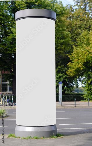 Empty advertising pillar in a city with white  free copy space, promotion mock up. Blank advertising panel