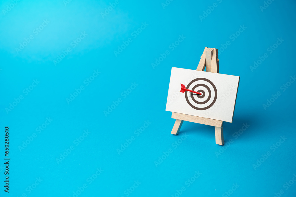 The red arrow hits the center of the target. Right on target on the first try. Advertising, marketing and targeting. Clear and specific goals. Accurate decisions. Archery. Striving for excellence - obrazy, fototapety, plakaty 