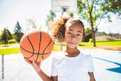 girl with basketball on court on summer season