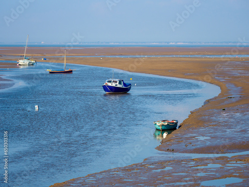 Small boats in the harbour at low tide Meols beach Wirral UK photo