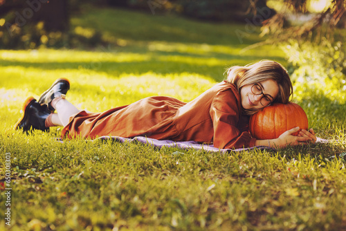 Beautiful young woman have a leisure sleeping on a pumpkin