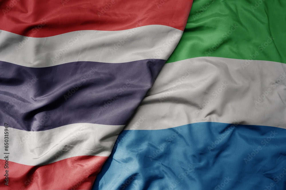 big waving national colorful flag of thailand and national flag of sierra leone . big waving national colorful flag of thailand and national flag of sierra leone .