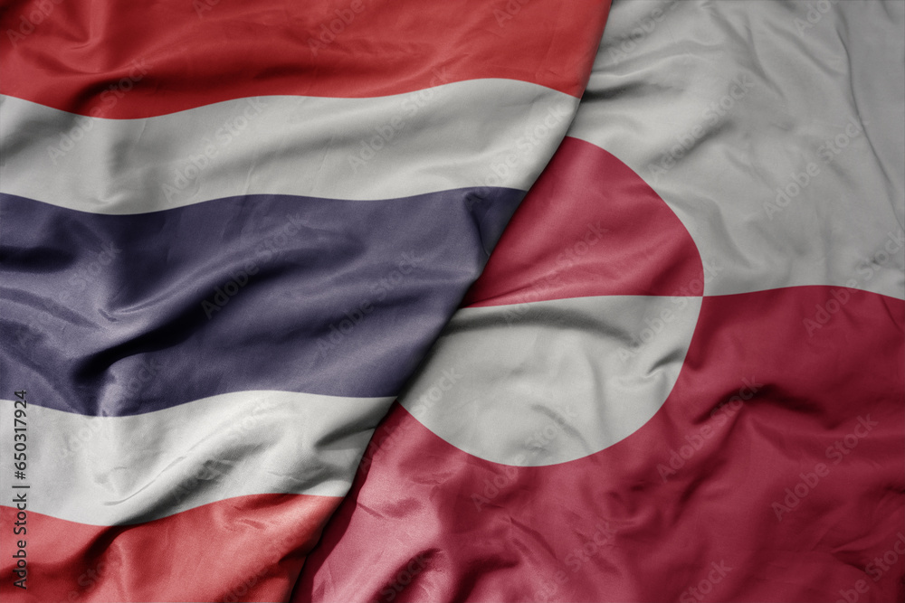big waving national colorful flag of thailand and national flag of greenland .