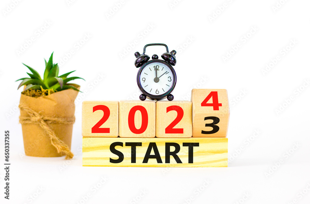 2024 start new year symbol. Businessman turns a wooden cube and changes