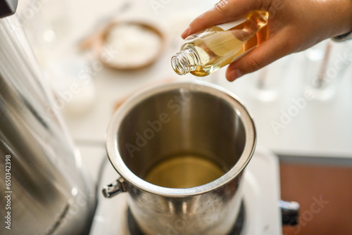 Woman pouring scent for candles, manufacturing process