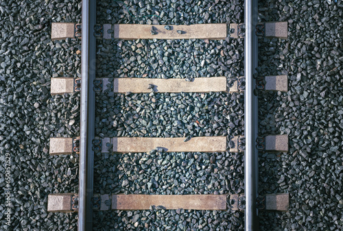 Close-up of train tracks taken from above. This close-up aerial view meticulously showcases the train tracks and steel rails, emphasizing the texture and materials used in the railway infrastructure. 