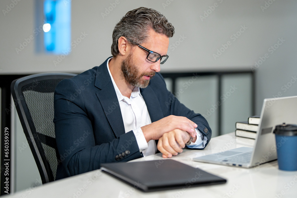 Office worker with laptop at office. Ofice employee remote working in modern office. Businessman on remote meeting, working online in offices place. Business man using computer in office.