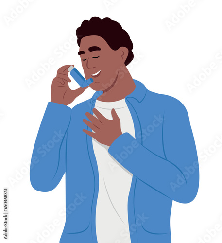 Young smiling man uses an asthma inhaler against attack. World asthma day. Bronchial asthma. Allergy, asthmatic. Inhalation drug.