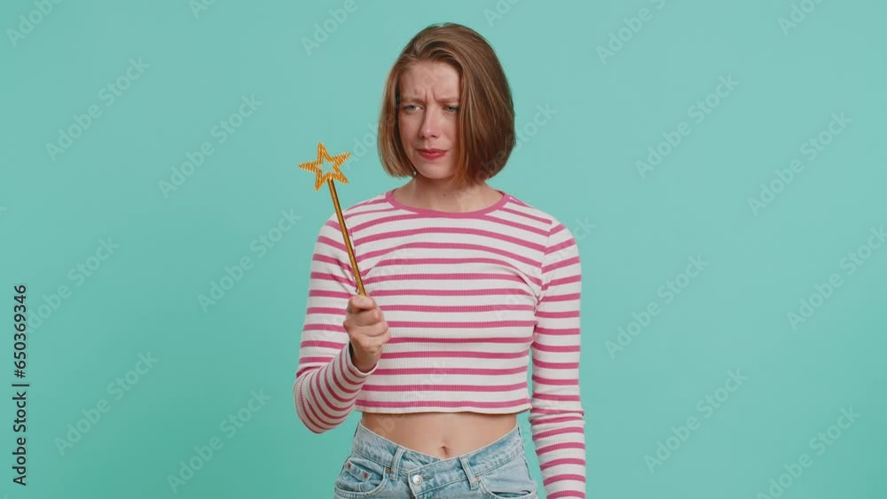 Magician witch wizard woman gesturing with magic wand fairy stick, making wish come true, casting magician spell advertising holidays sale discount. Girl in crop top isolated on blue studio background