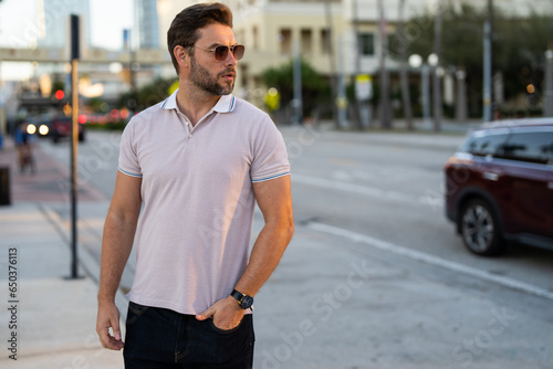 Portrait of handsome confident stylish man in big city. Sexy man in casual clothes posing on the street. Successful male model in the urban lifestyle. Caucasian middle aged man outdoors.